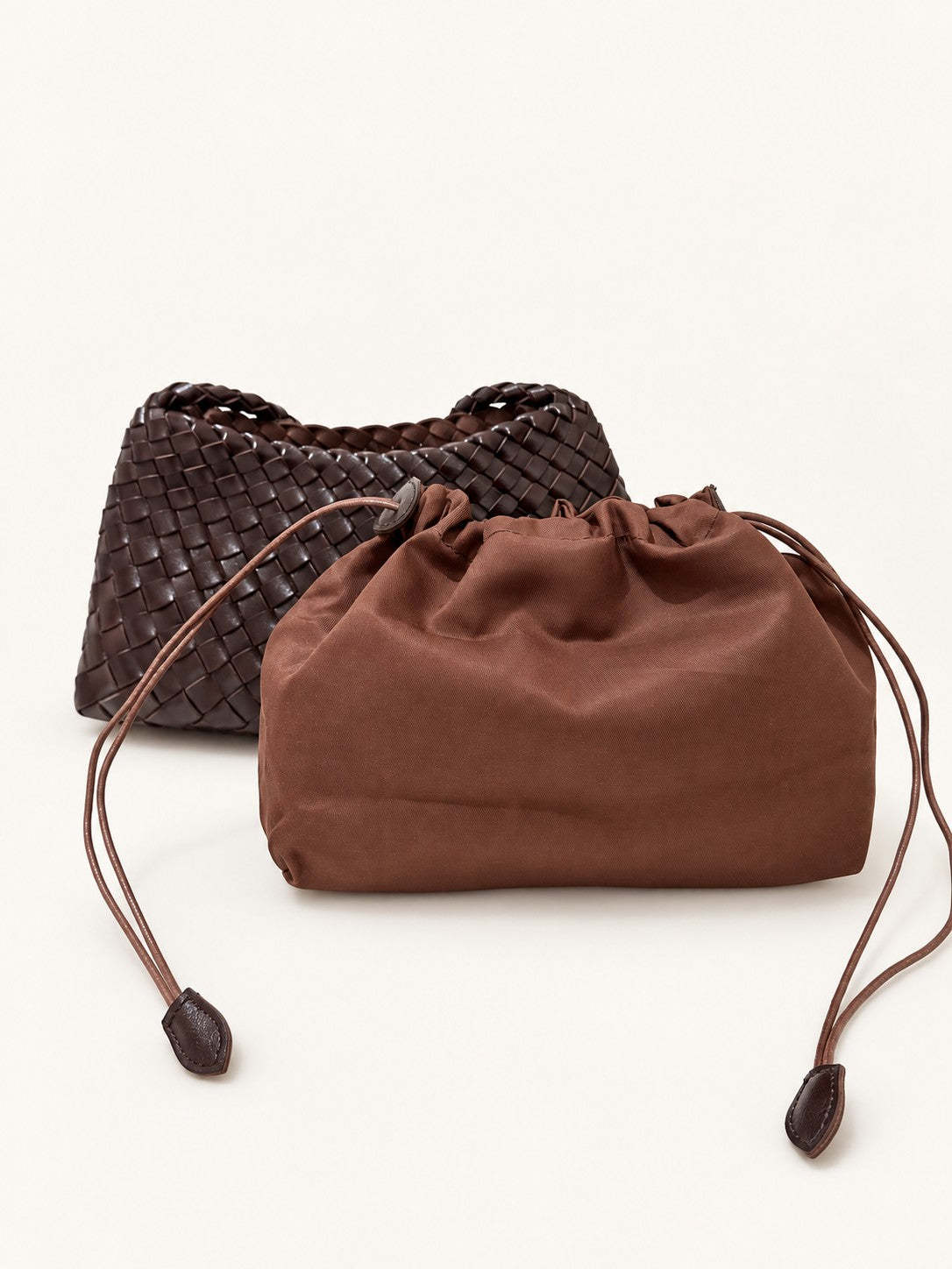 咖啡色光面 Vegan Leather 編織肩背包與束口內袋，內袋附拉鍊夾層、可單獨使用