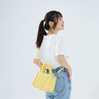 CIPU 澎澎手提包 淺黃色 Free Size 模特兒側身斜背展示，搭配白色T恤與牛仔褲