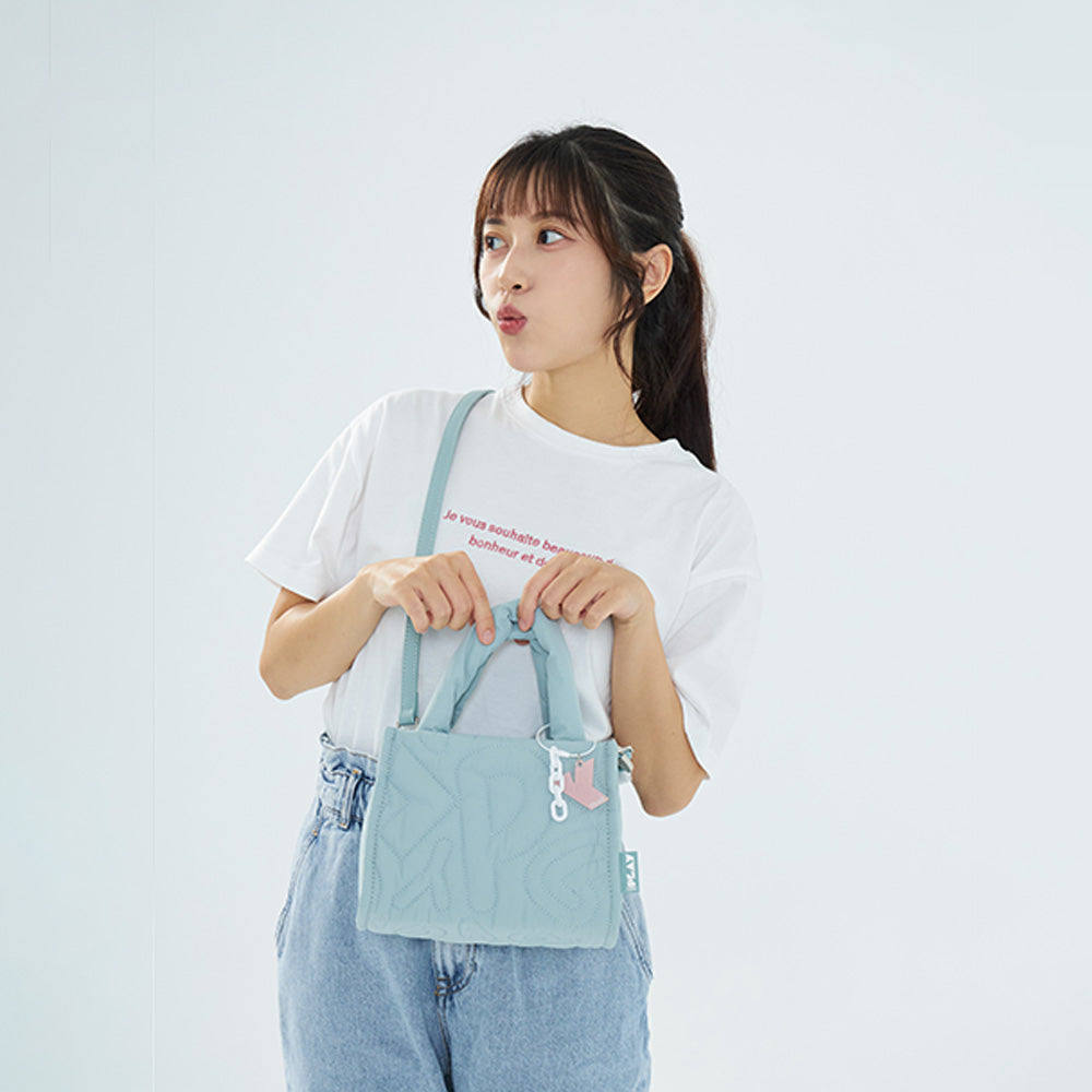 CIPU 澎澎手提包 莫蘭迪綠  模特兒手提正面展示，搭配白色T恤與牛仔褲