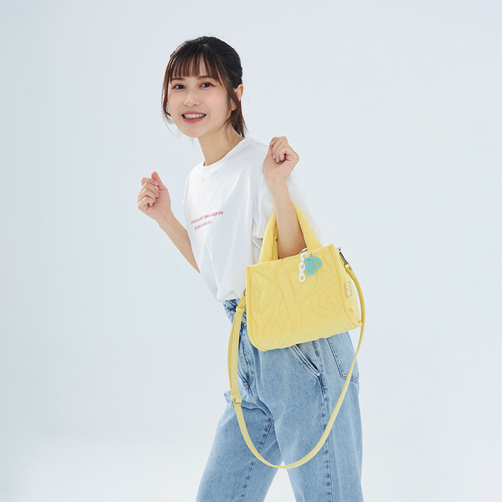CIPU 澎澎手提包 淺黃色 Free Size 模特兒斜背正面展示，搭配白色T恤與牛仔褲