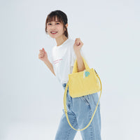 CIPU 澎澎手提包 淺黃色 Free Size 模特兒斜背正面展示，搭配白色T恤與牛仔褲