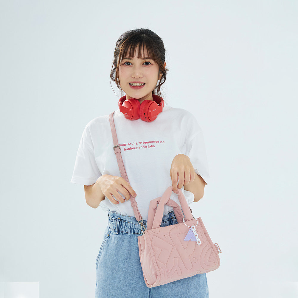 CIPU 澎澎手提包 PLAY 藕粉 模特兒斜背正面展示，搭配白色T恤、牛仔褲與紅色耳機